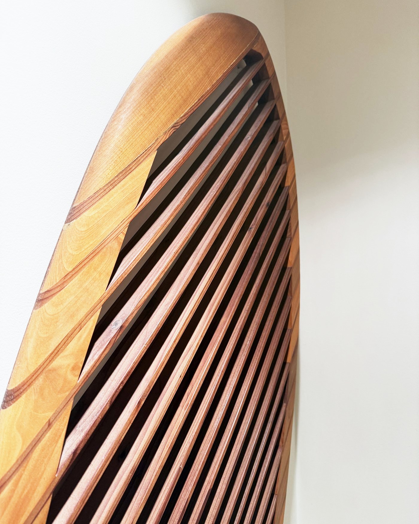 The nose of the board seen from below, with slats meeting the cedar rail.