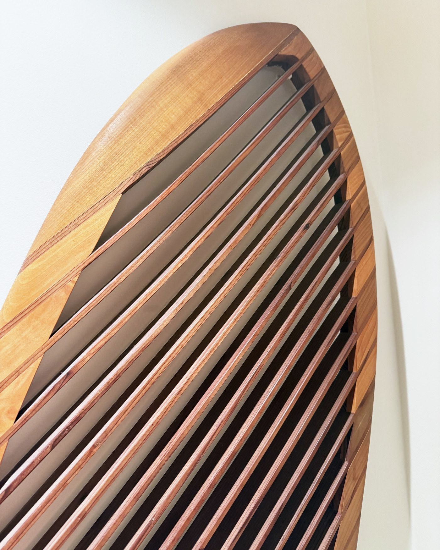 The nose of the board, showing the redwood slats against the wall.